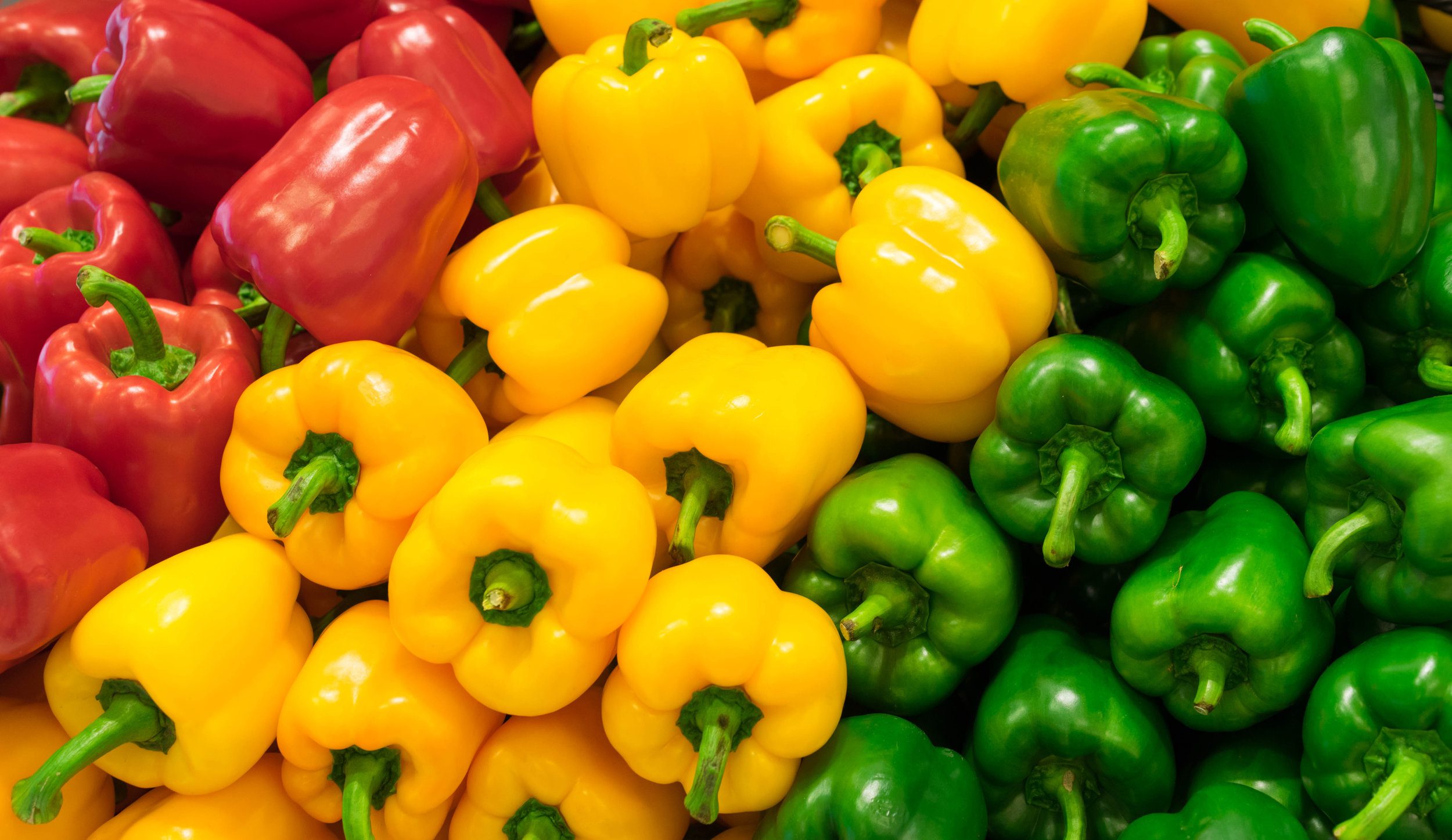 Red, yellow, and green bell peppers (capsicum) background