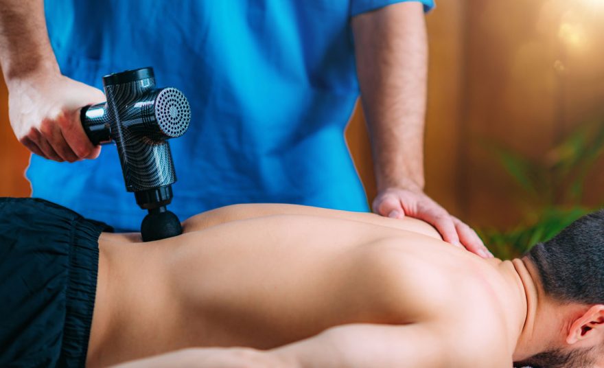 https://wellnessdoctorrx.com/wp-content/uploads/2021/04/massage-gun-treatment-physical-therapist-massaging-EESEKKK_02-880x536.jpg